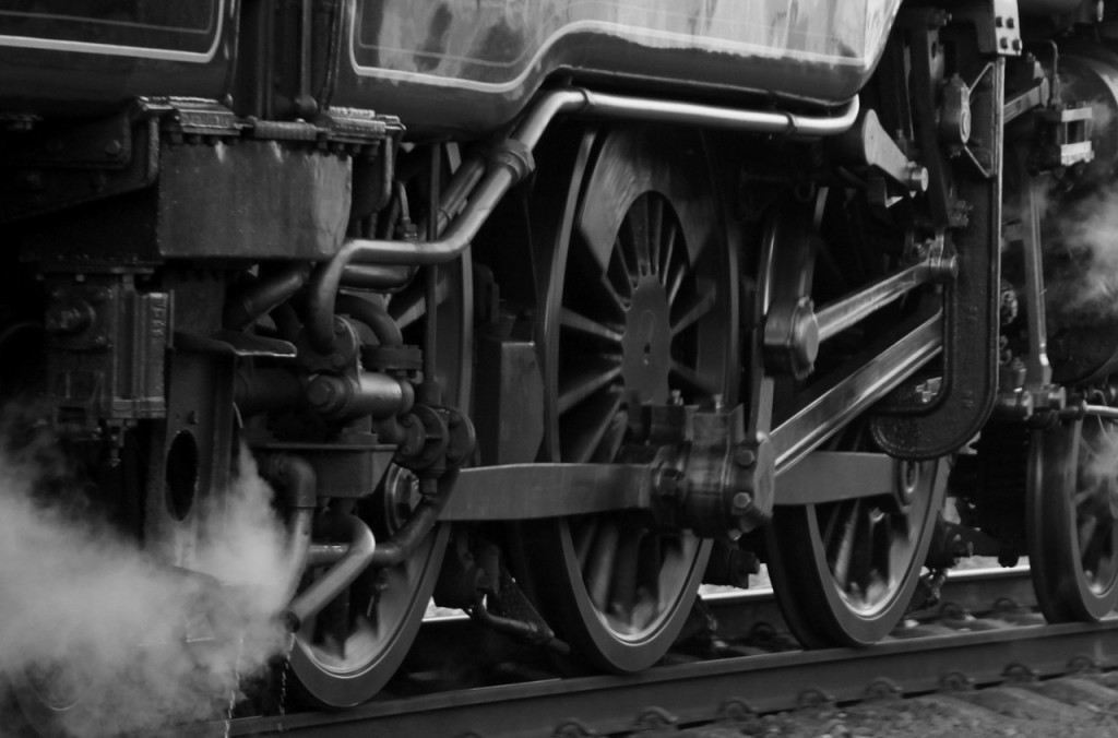 The wheels and the bottom half of a train. There's steam coming out of it.
