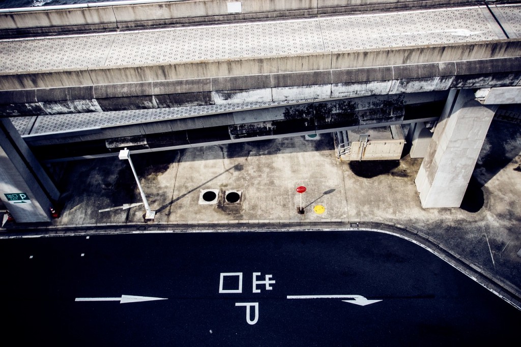 The Umihotaru parking area; a blacktop area next to concrete structures.