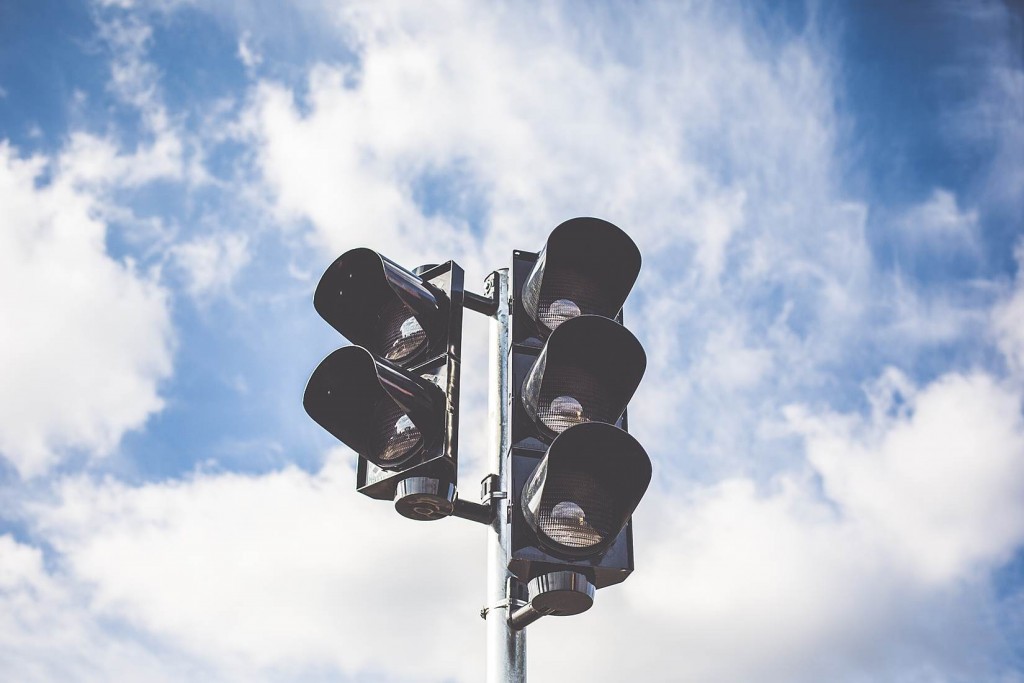 A traffic light with a cloudy sky behind it.