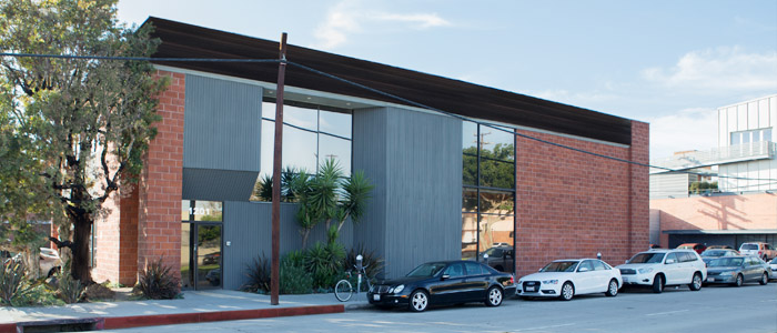 The outside of the Local Hero offices with cars parked in front of it.