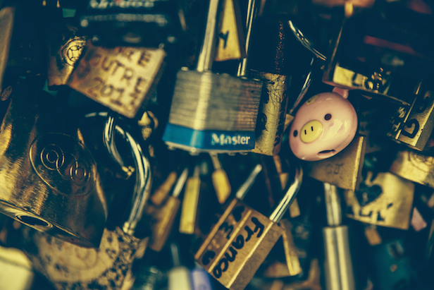 A whole bunch of locks, some with names and words written on them.