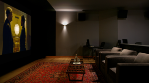 A home theatre room showing a movie with 2 men talking to each other.