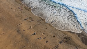 Photograph of people on a beach taken from high above.