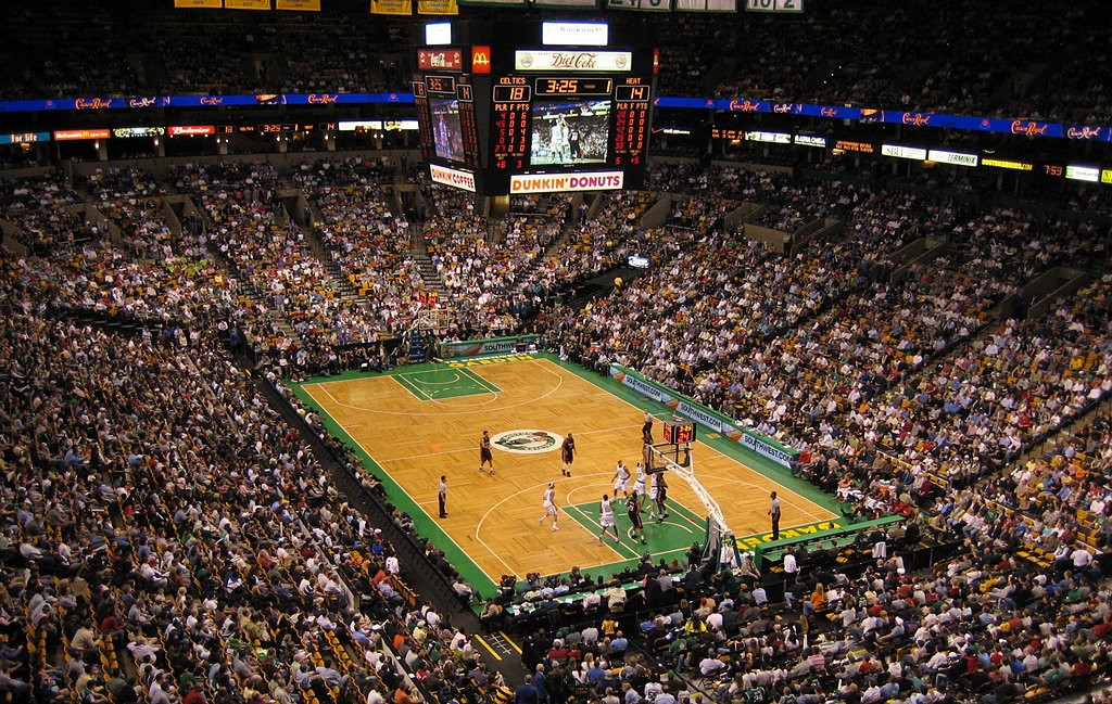 NBA players playing a basketball game in a packed stadium.