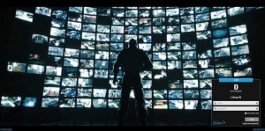 A man standing in front of a gigantic wall of monitors. There is a Digital Dimension login screen at the bottom.