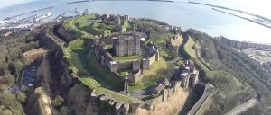 An aerial view of Dover Castle and the surrounding area of green terraces and the English channel.