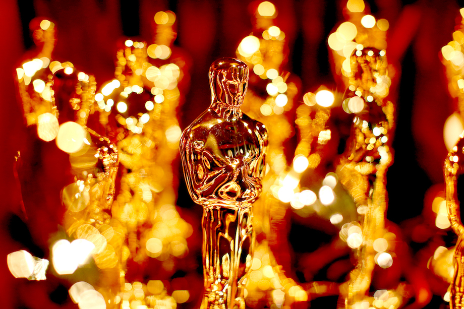 Several Oscar award statues in a group, only one is in focus.