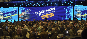 A large group of people at tables eating at the luncheon at NAB Show.