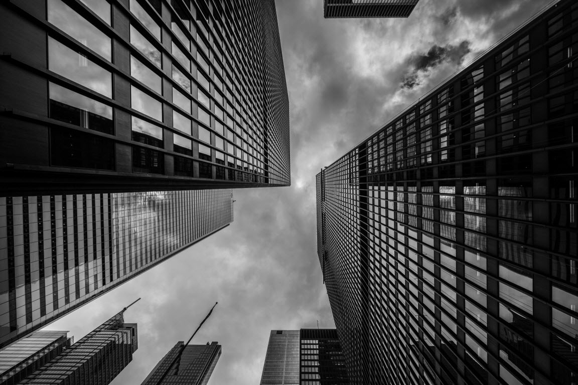 Looking up from the street at several skyscrapers.