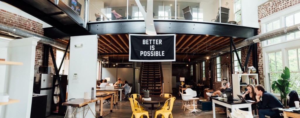 The inside of a business with people working in different areas. There's a sign that says Better is Possible.