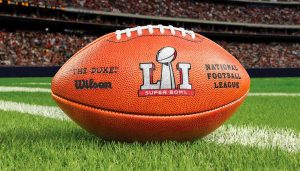 A closeup of a football on a football field during the Super Bowl LI.