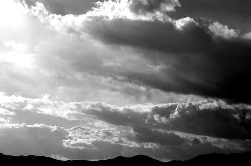A cloudy sky with mountain ranges at the bottom.