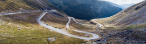 The Transfagarasan road that is very windy and traverses a valley between mountain peaks.