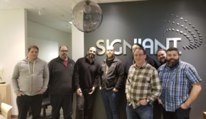 A group of eight men standing in the front of the Signiant Ottawa offices.