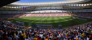 A large stadium filled with people watching a soccer game.