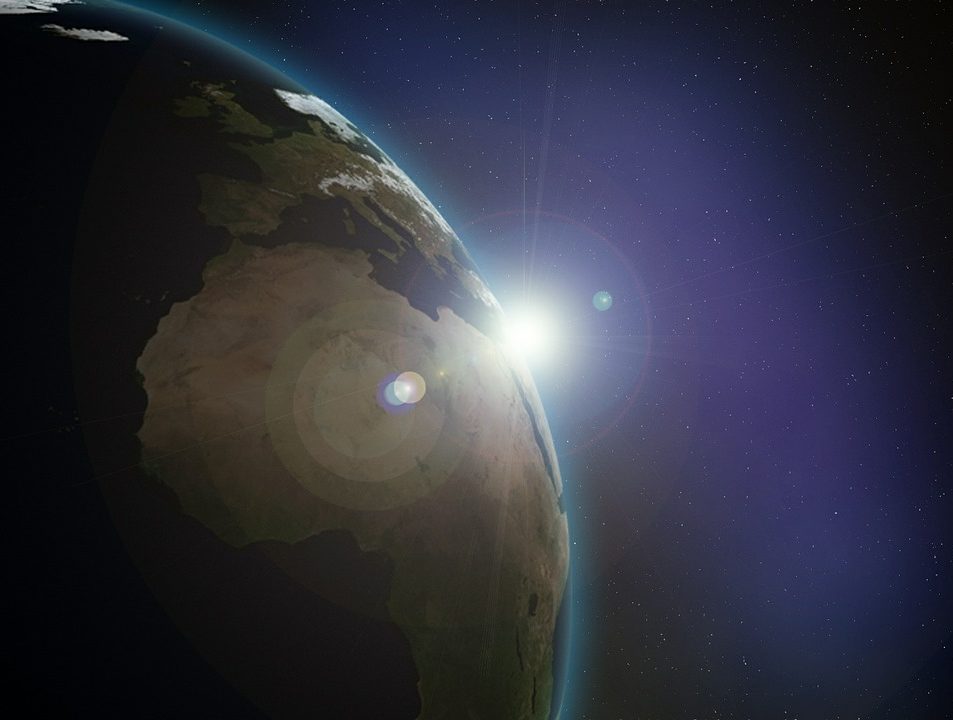 The Earth seen from space, with the sun coming around the side of it.