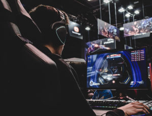A man in a gaming chair, wearing a headset and playing esports.