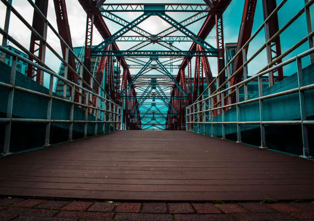 A large foot bridge with tall buildings around it.