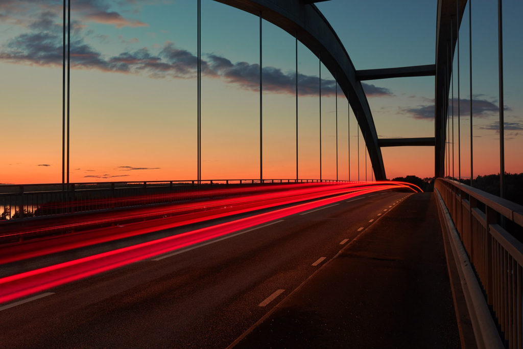 A time lapse of cars driving over a bridge.