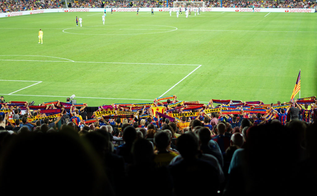 Soccer players on a field in a full stadium.