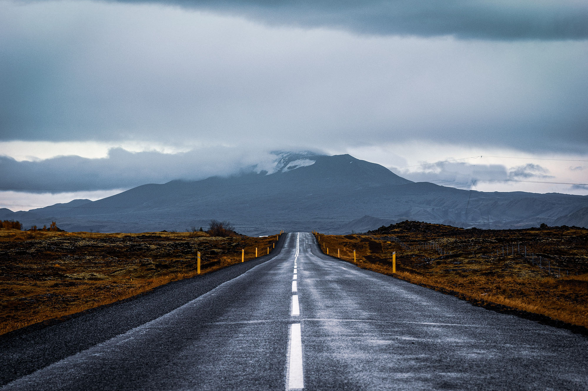 An empty road heading towards a mountain.